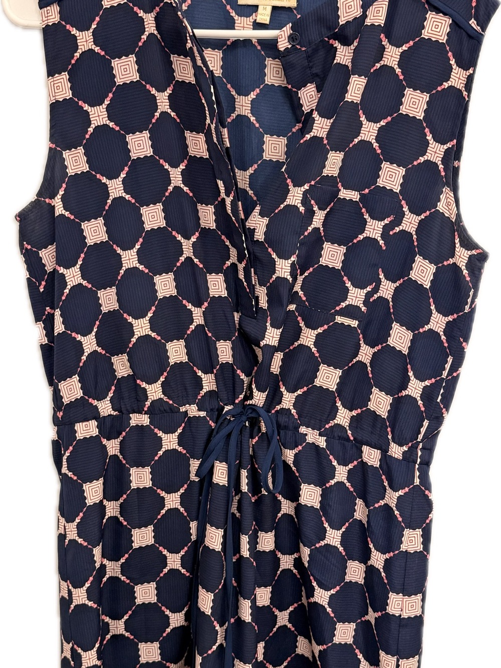 Navy women’s dress with geometric pattern and cinched waist.